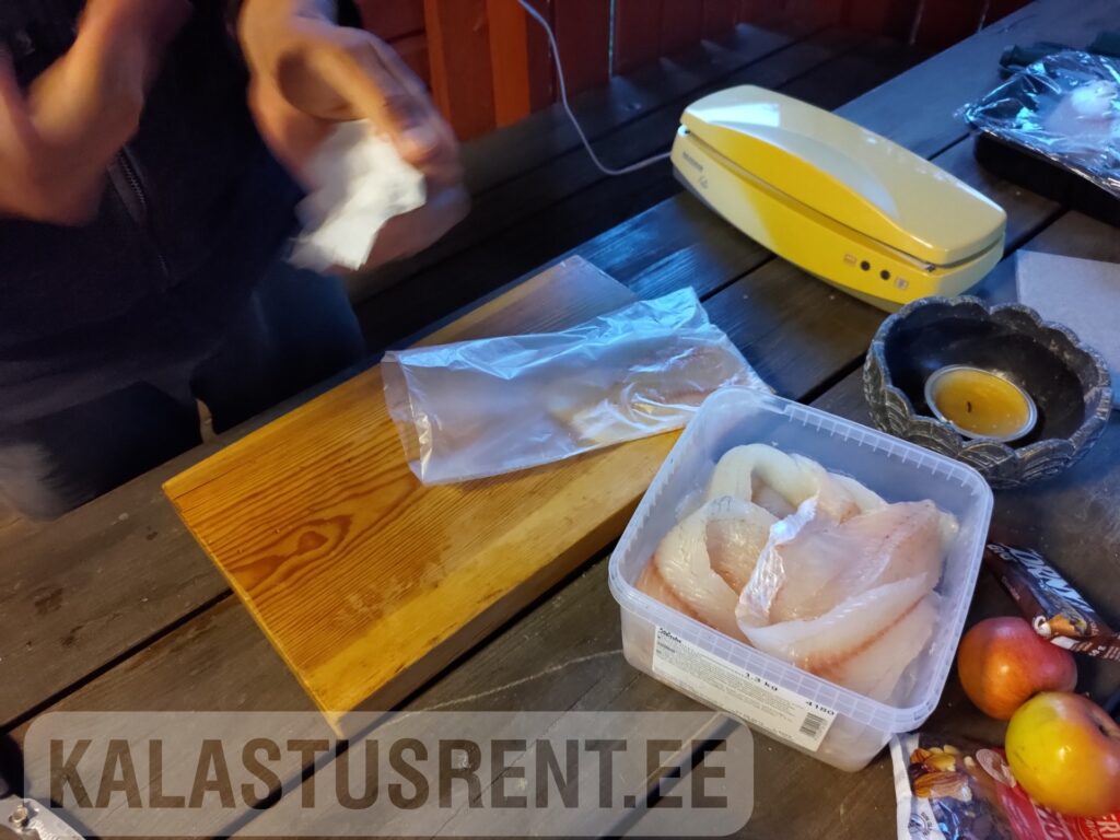 Kalastusrent.ee – kala vaakumpakendamine ja ettevalmistus sügavkülmutamiseks. Fileeritud kala karbis ja vaakumkott tööpinnal koos vaakumpakendajaga.
