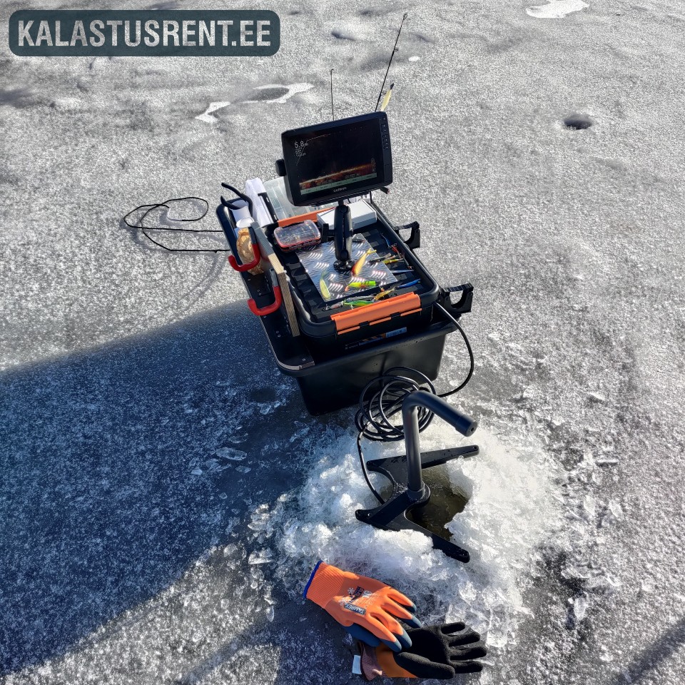 Jääpüügivarustus järvejääl: kalastuskastile kinnitatud live-kajaloodi ekraan ja andur jääaugus, ümberringi tarvikud ja kindad, taustal jäine veepind.